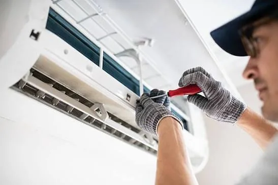 Technician model working on a wall-mounted ductless air conditioning unit