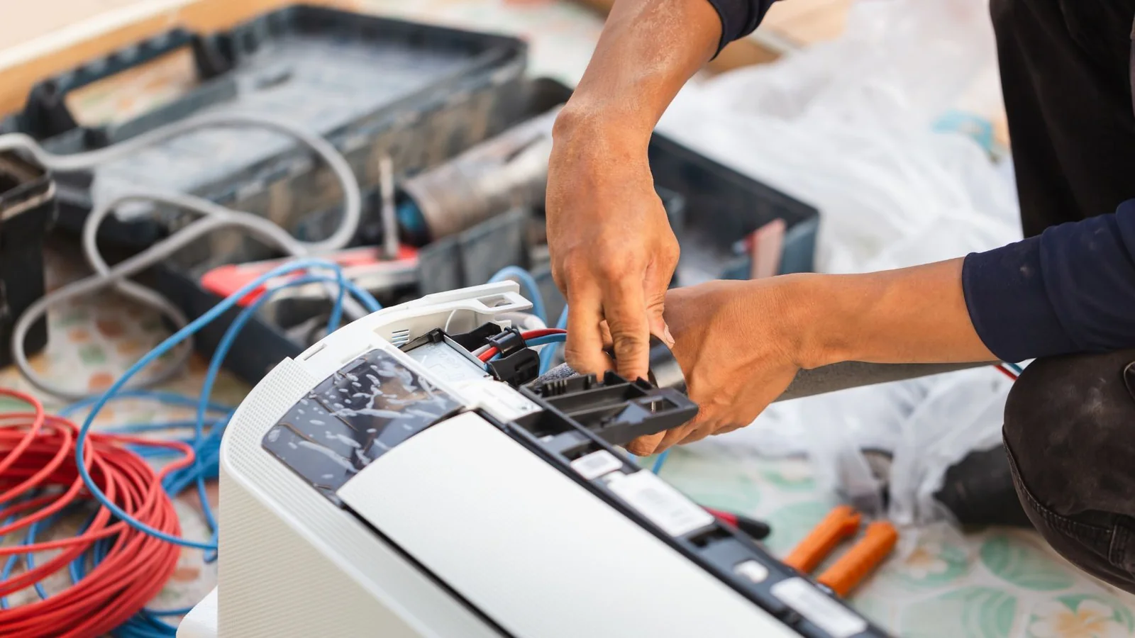 Technician model repairing indoor HVAC controls with wiring and service tools